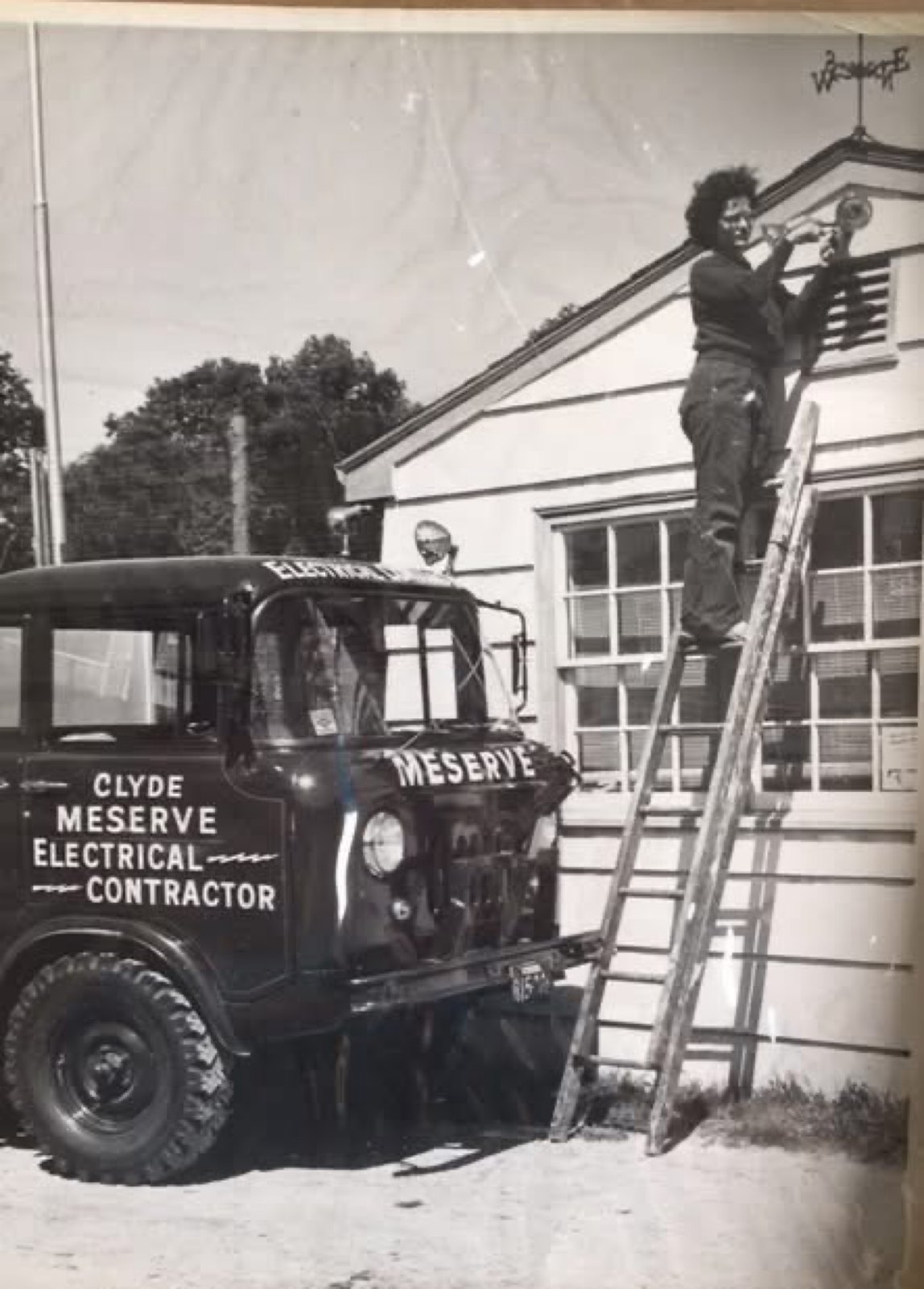 Deanna Dunlevy, Clyde Meserve’s apprentice, on a ladder beside the Clyde Meserve Electrical Contractor truck